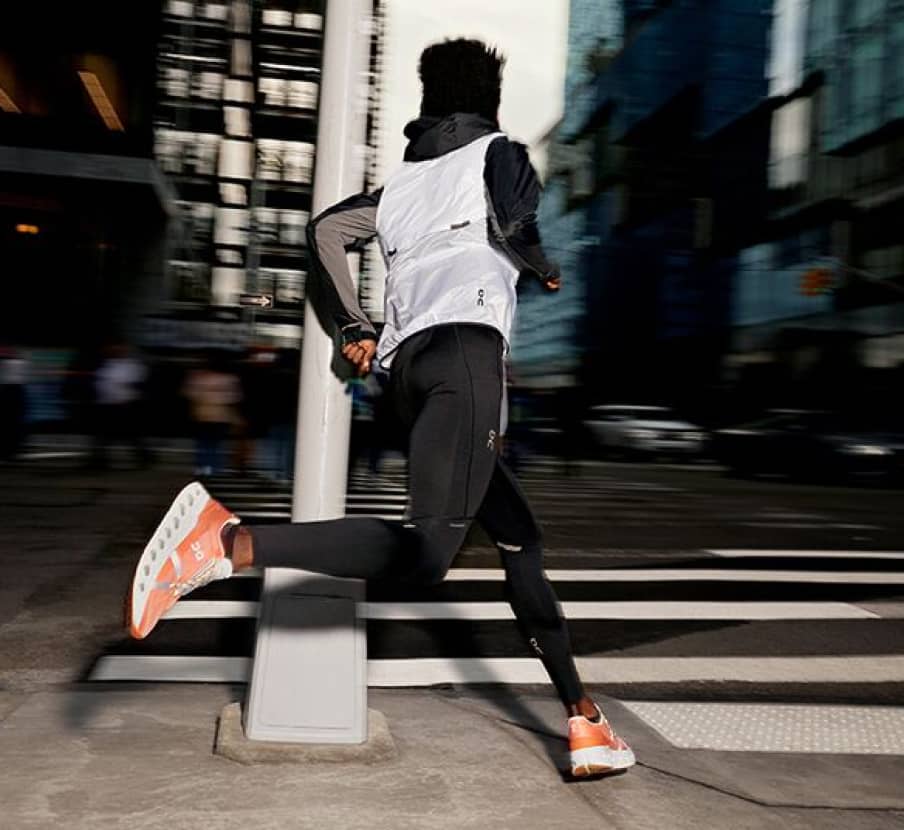 imagen de un hombre correindo en la calle con ropa deportiva, ON