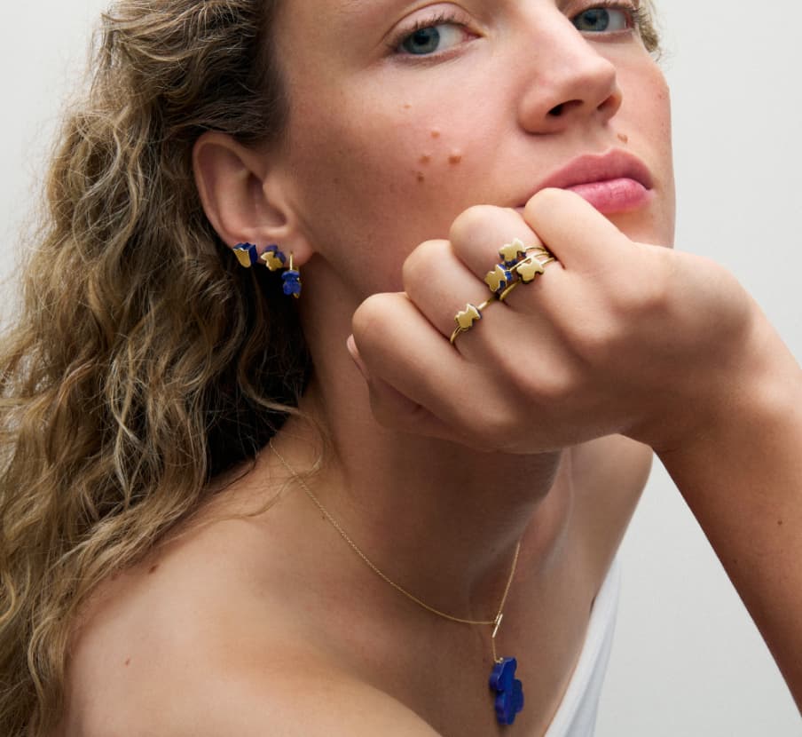 Imagen de mujer con accesorios dorados con azul de la marca TOUS