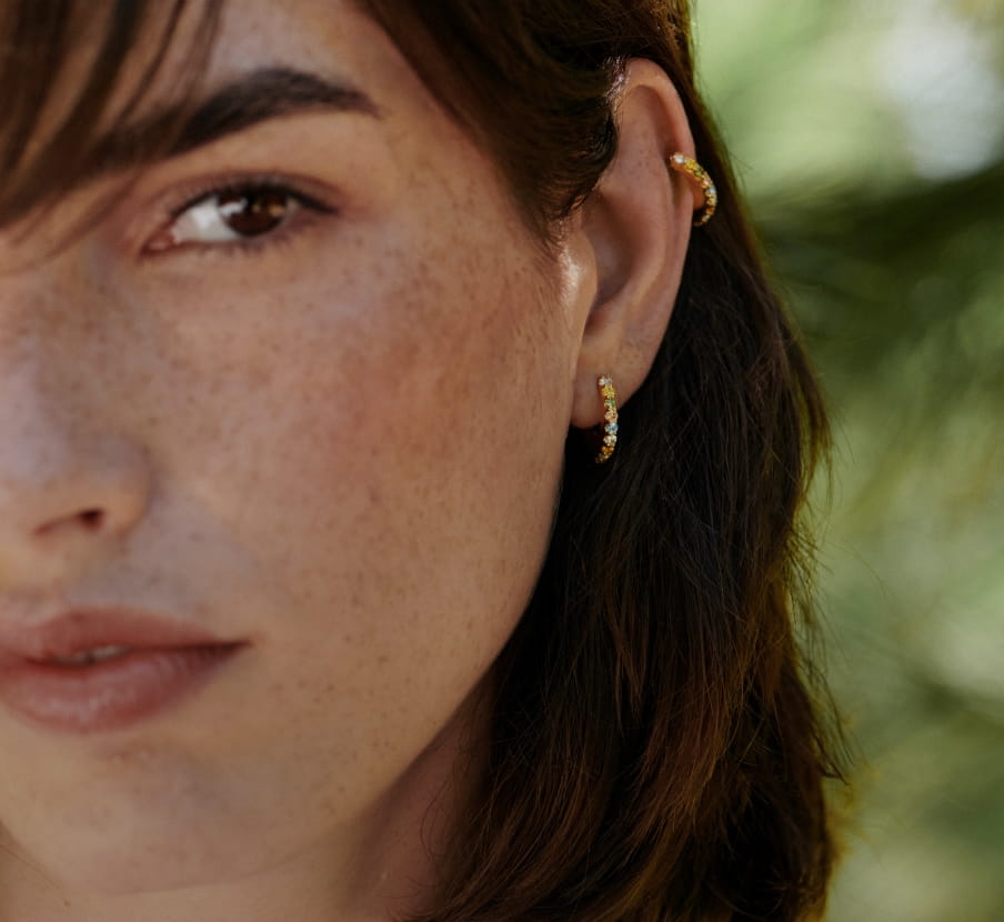 imagen de mujer de cabello negro con 2 aretes dorados, PDPAOLA