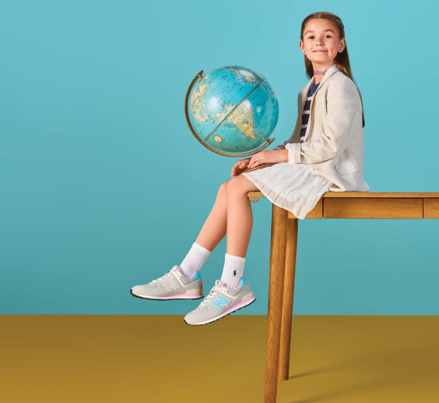 Imagen de niña con globo terraqueo sentada en un escritorio, KIDS