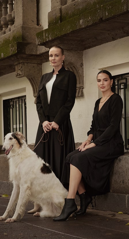 imagen de dos mujeres con su perro, llevan vestidos largos de color negro PERTEGAZ