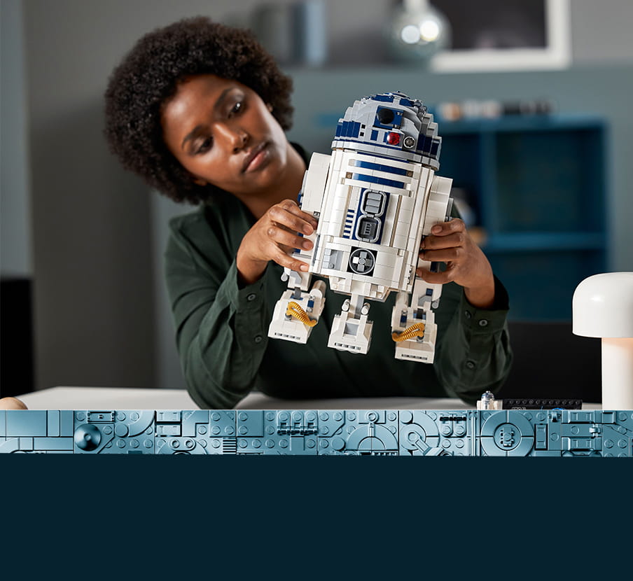 Mujer armando figura de R2D2. LEGO