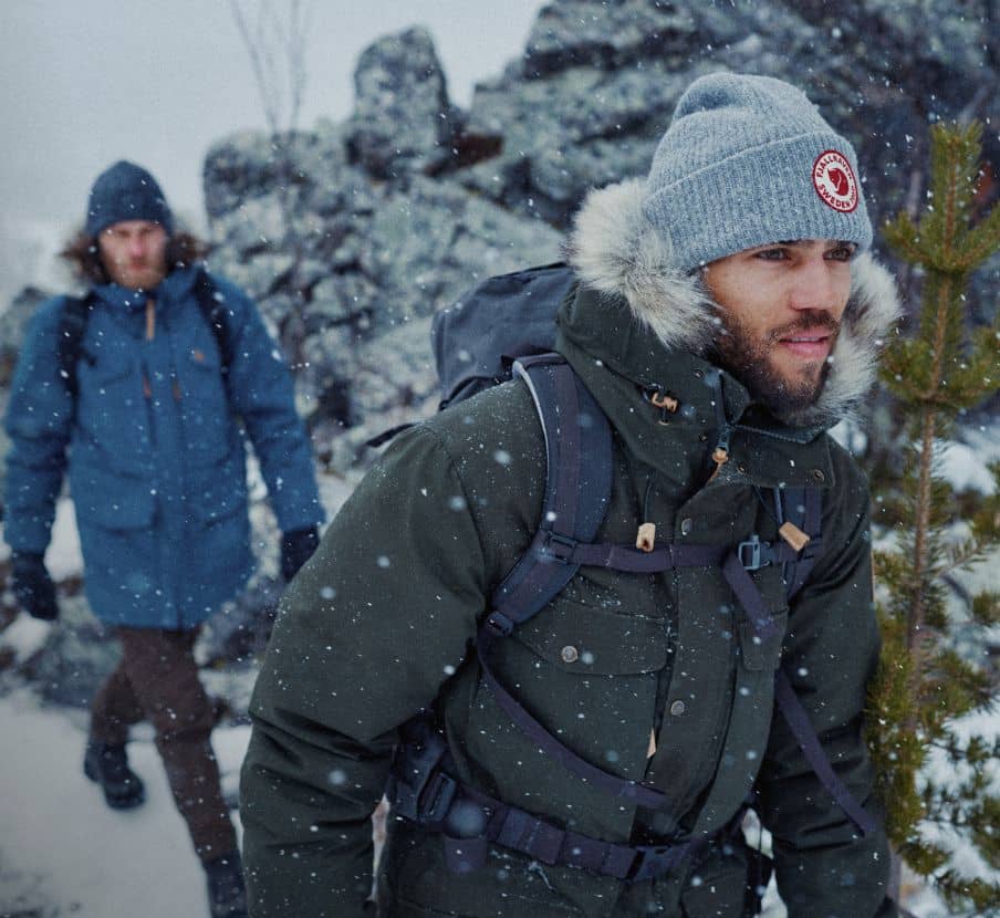 imagen de dos hombres caminando por la nieve, fjallraven