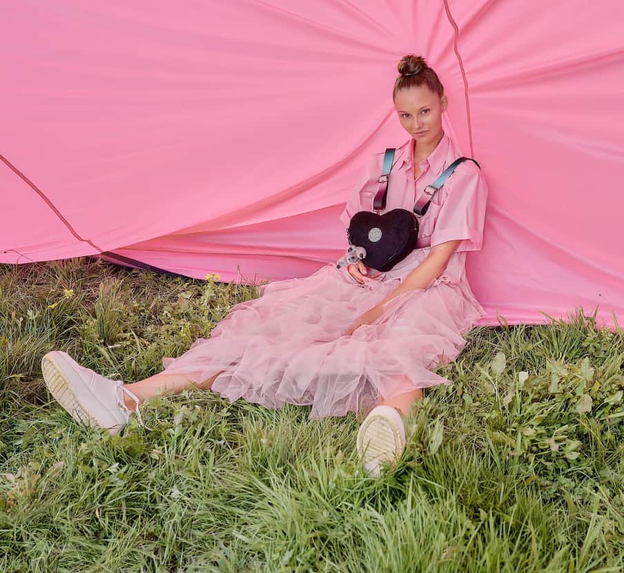 imagen de mujer con ropa rosa y bolso negro de la marca KIPLING